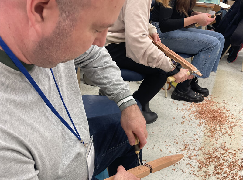 A group of people sitting and whittling.